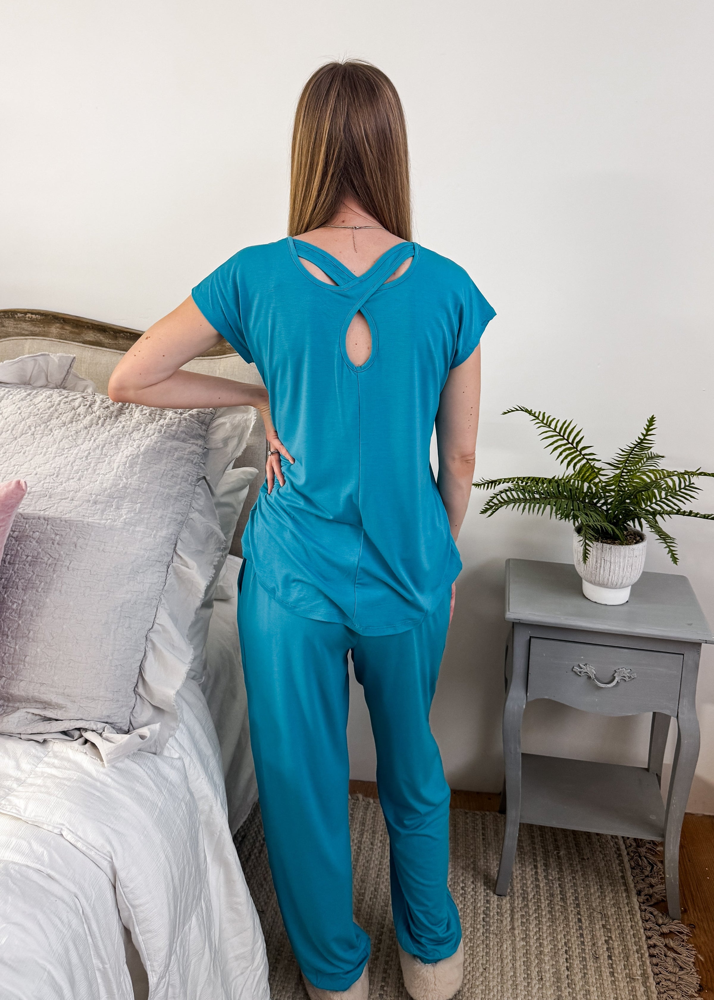 Model showing the back of the Cool Girl Aqua Tee, highlighting the unique criss-cross keyhole back detail