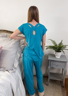 Model showing the back of the Cool Girl Aqua Tee, highlighting the unique criss-cross keyhole back detail