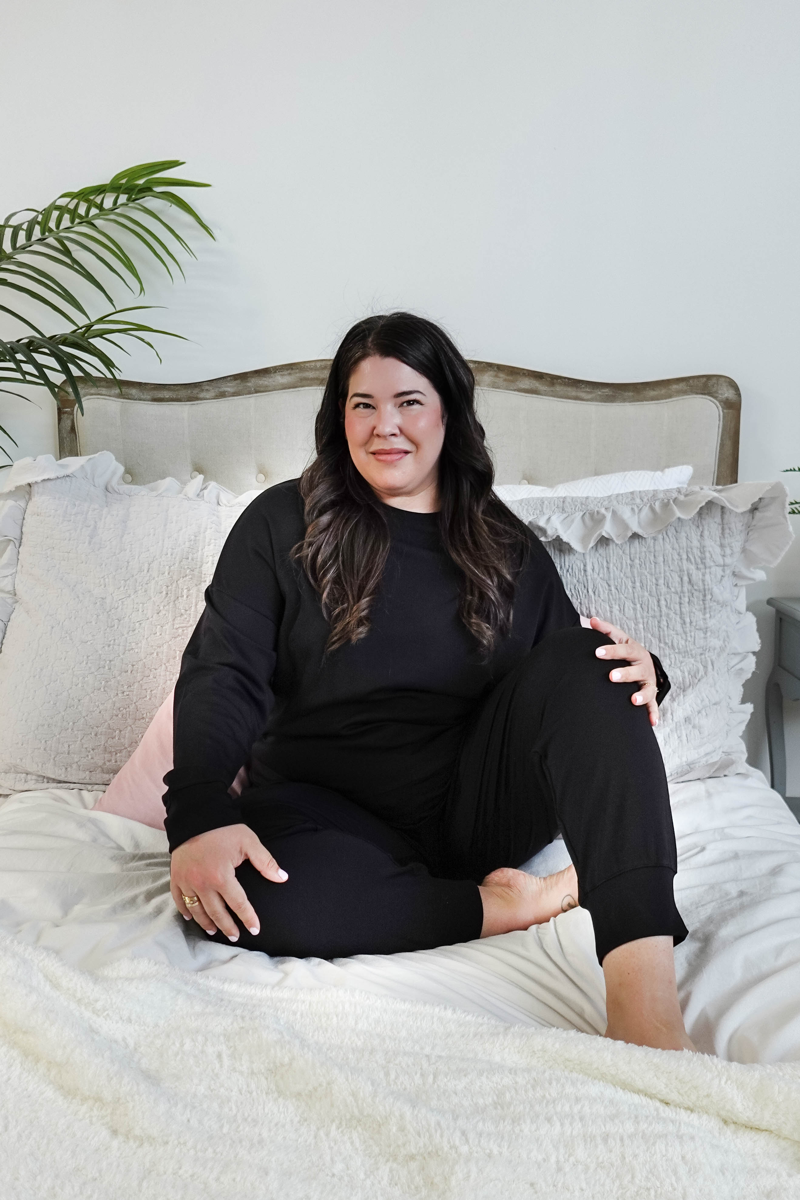 plus size woman sitting wearing black lounge set with top and jogger in bamboo blend