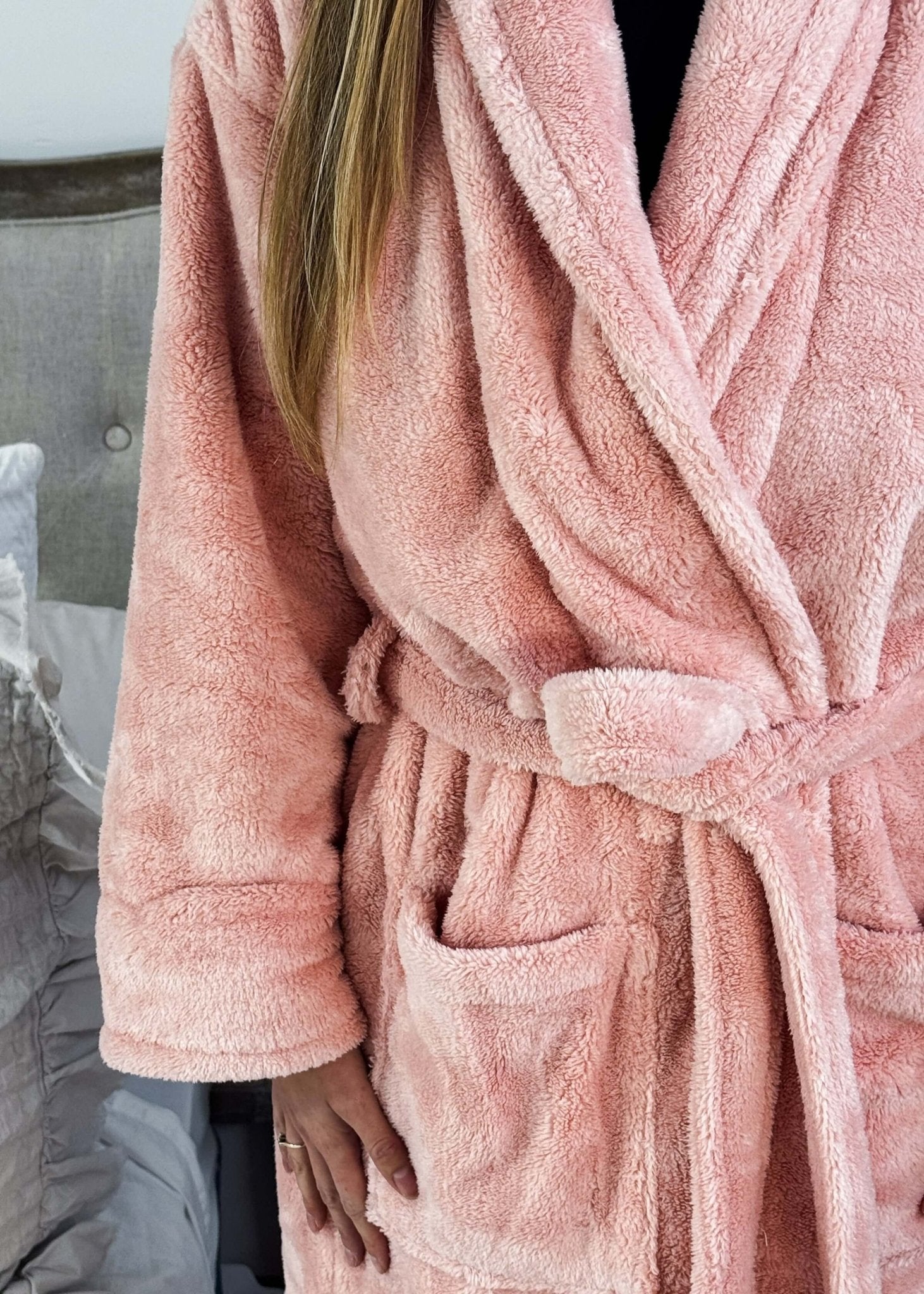 WARM BUDDY - Cozy Ultra Plush Spa Robe in Pink, Shown on a women in a bedroom setting, showing texture of the robe's plush fabric and tie waist, pocket details