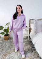 Person wearing a purple loungewear set in a bedroom.