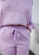 Person wearing a matching lavender hoodie and jogger set with a neutral background.