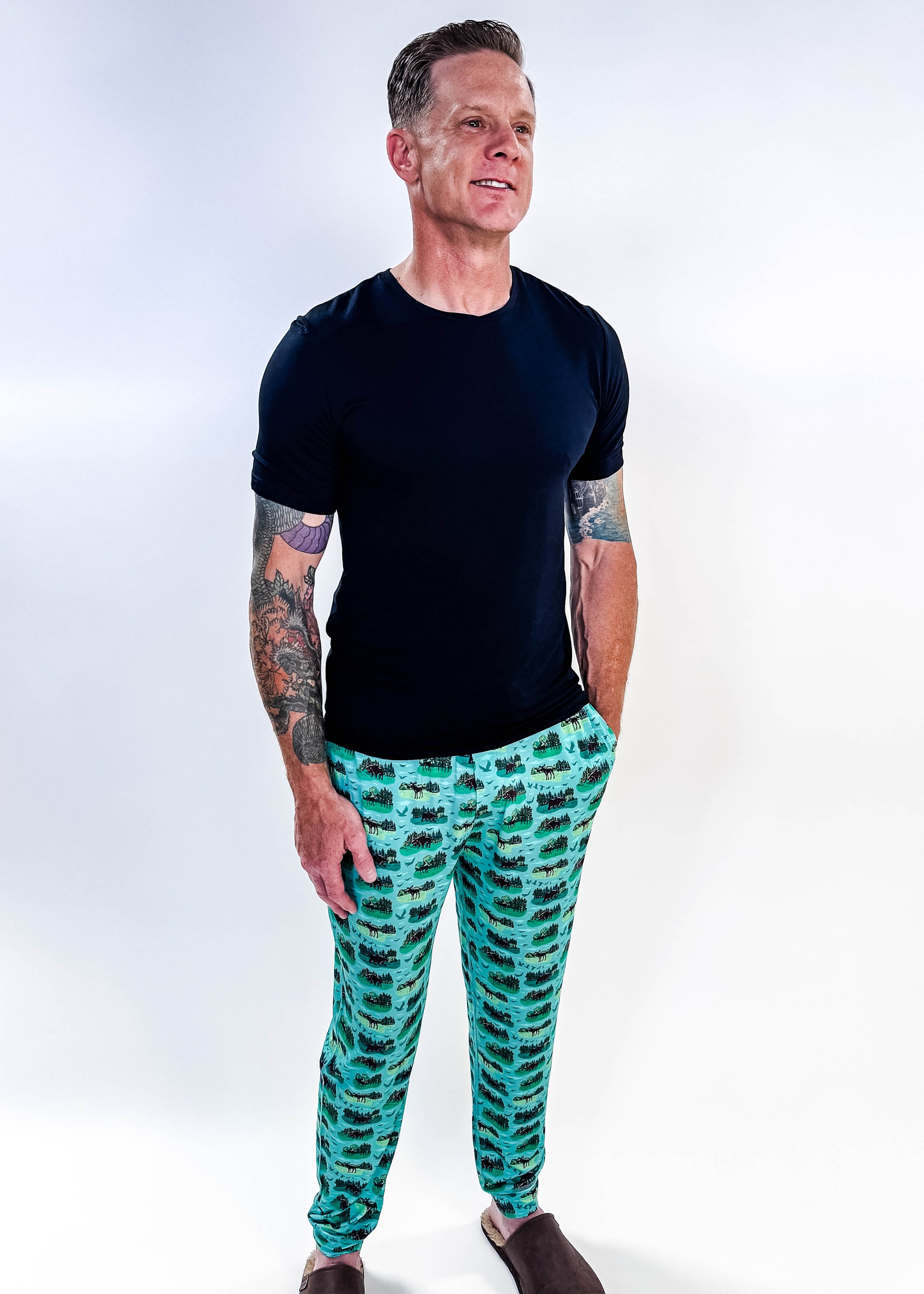 Model wearing Wildlife Aqua Unisex Bamboo Joggers with a black t-shirt, showcasing vibrant aquatic print.