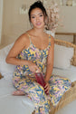 Cami & High Waist Capri PJ Set worn by a woman relaxing on a couch with a drink, featuring a tropical print design.